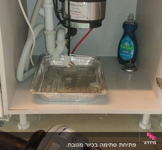 כלי עבודה של אינסטלטור מתחת לכיור מטבח